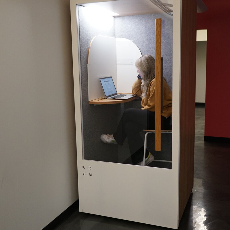 Member on a call inside a privacy booth